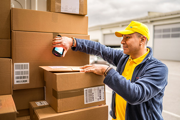 Courier using an handheld to scan packages.